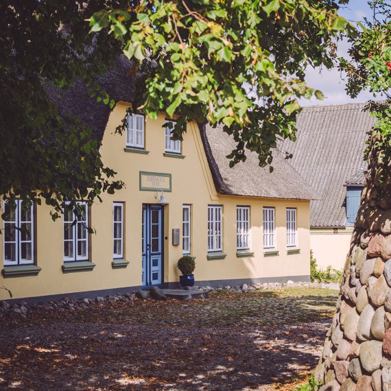 Gelbes Haus in Schweden (Mohrkirch, Schleswig-Holstein) im Schatten von Bäumen
